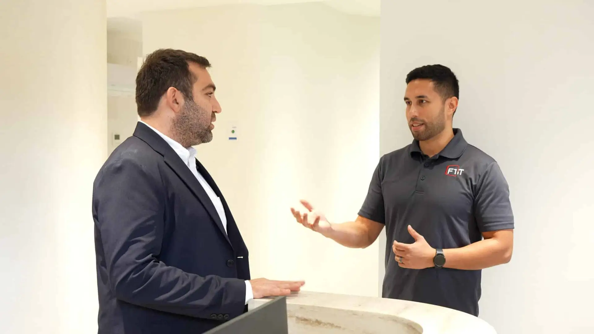 William Kohl and Dr. Mehdi Aryan of Plaza Dental Arts talking in a modern reception