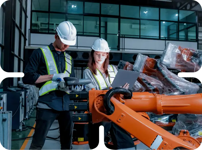 Workers examining robotic equipment in factory